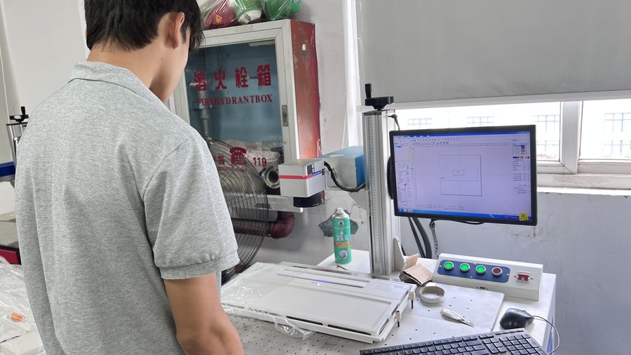 Operator running the laser marking machine for OEM logo engraving