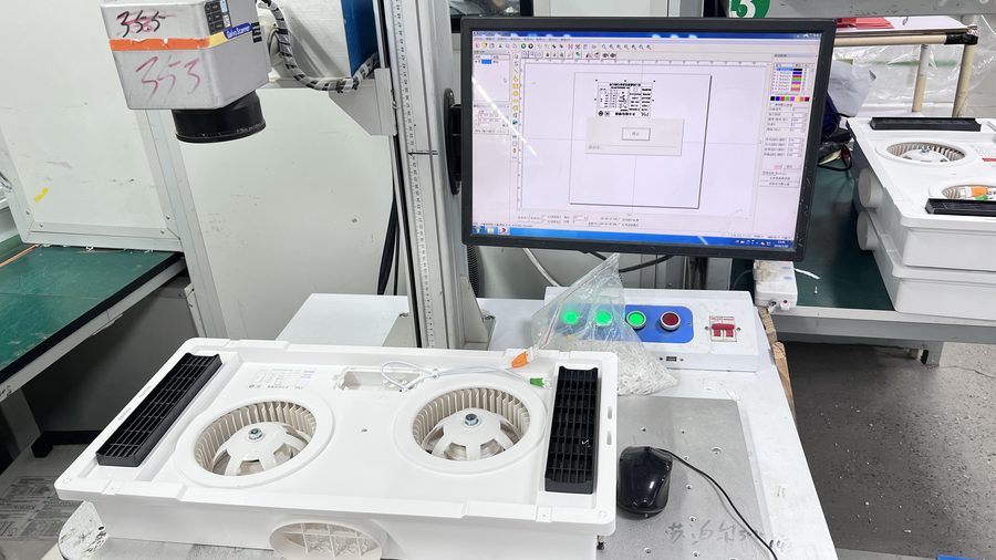 Laser marking machine engraving a logo on a water heater front panel